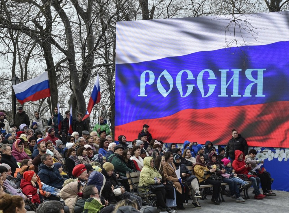 A screen with the word “Russia” on it looms over an event to mark the ninth anniversary of Russia‘s annexation of Crimea in Sevastopol, Crimea, 18 March 2023. Photo: EPA-EFE